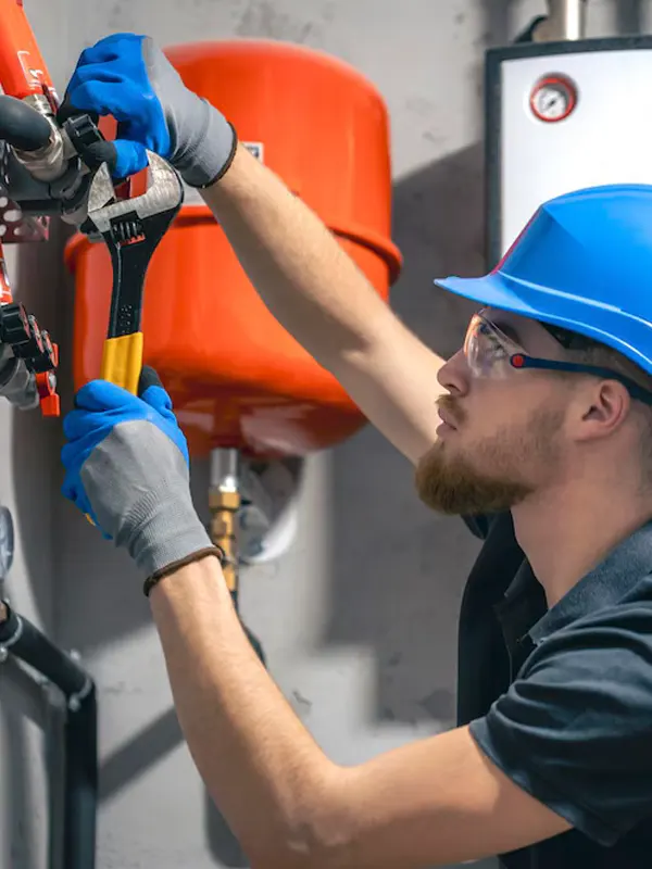 A heating tradesman doing a commercial heating repair service in an establishment in Jersey.