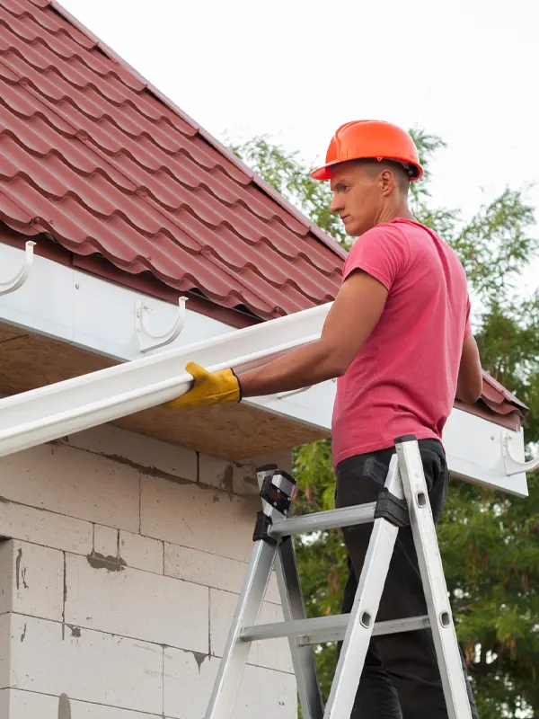 An expert roofer doing a guttering service in Jersey.