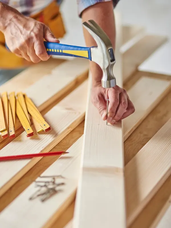 A floor carpenter doing a subfloor strengthening in a Jersey building.