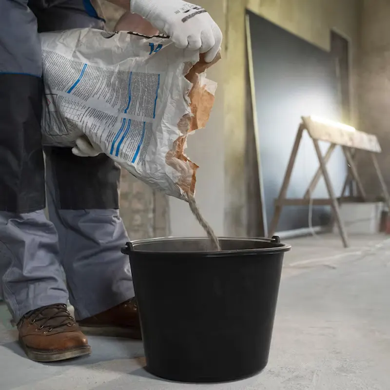 A Jersey plumbing professional preparing waterproof cement mix for damp proofing and leak prevention